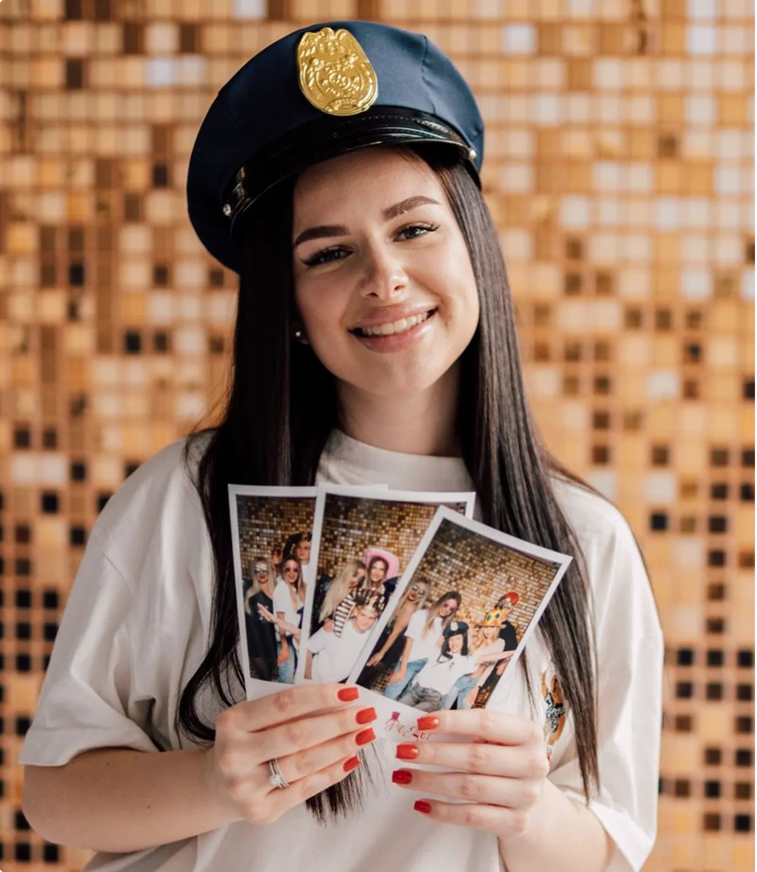 Guests holding freshly printed photo booth strips at a family celebration in Marbella