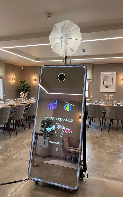 Photo booth set up in an event hall in Estepona with dressed dinner tables in the background