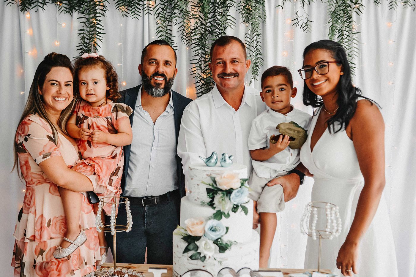 Familia reunida en torno a la tarta en una celebración de comunión o bautizo
