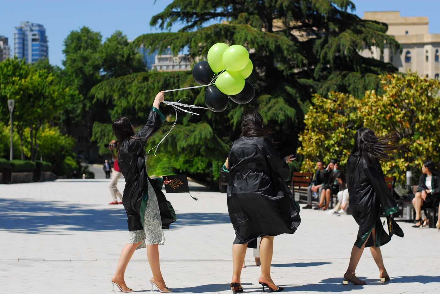 Graduados celebrando con globos en una fiesta de fin de curso al sol