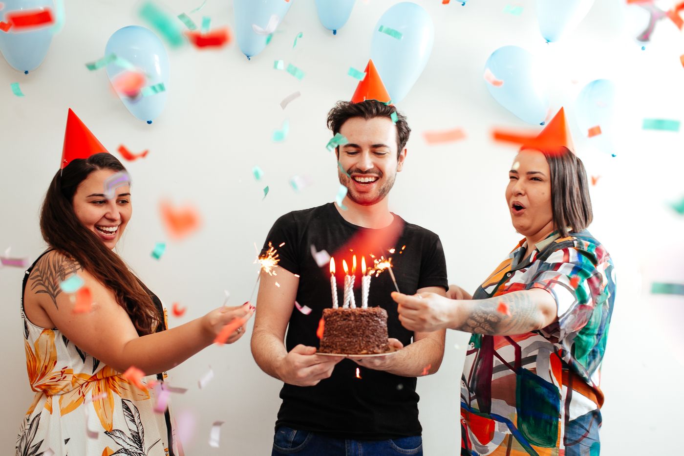 Grupo de amigos celebrando un cumplea&ntilde;os con confeti en una fiesta privada