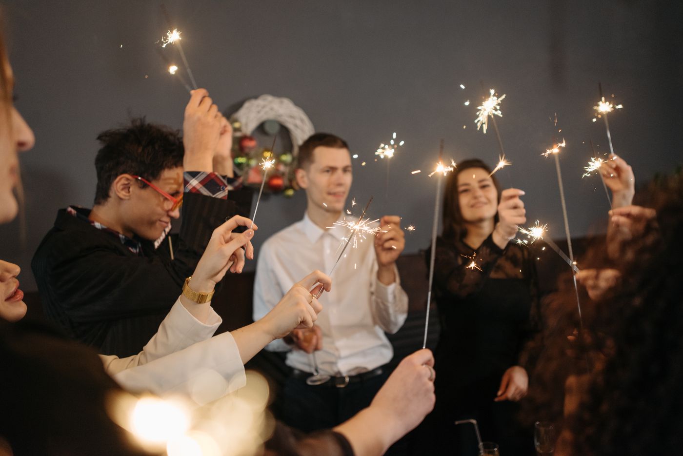 Invitados celebrando con luces de bengala en el salón de un hotel