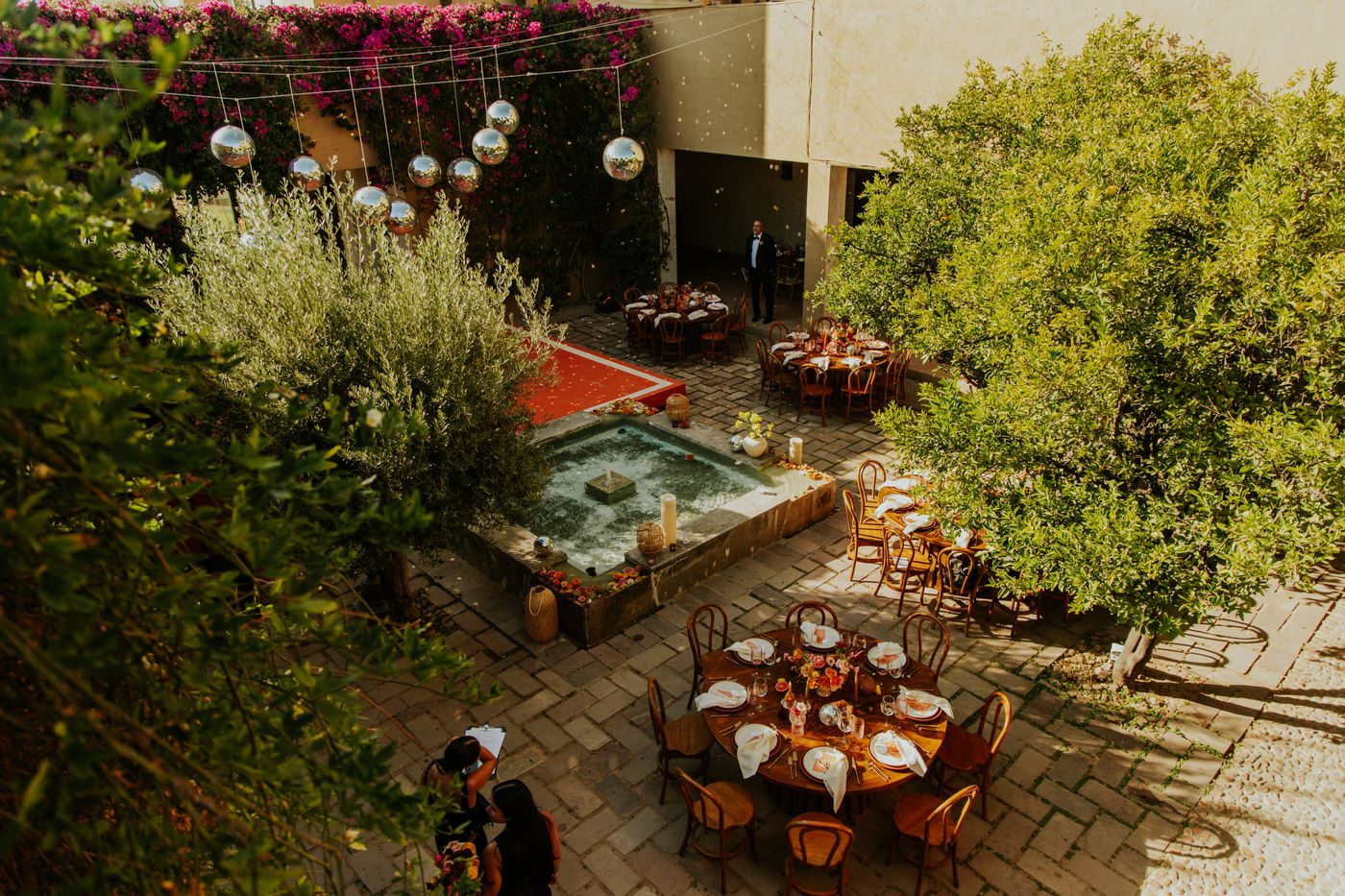 Zona de celebración de boda al aire libre con mesas y árboles decorados